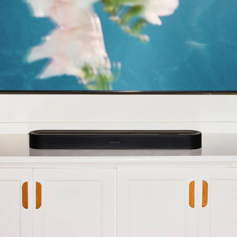 A black Sonos Beam Ultra soundbar placed on a media console below a TV