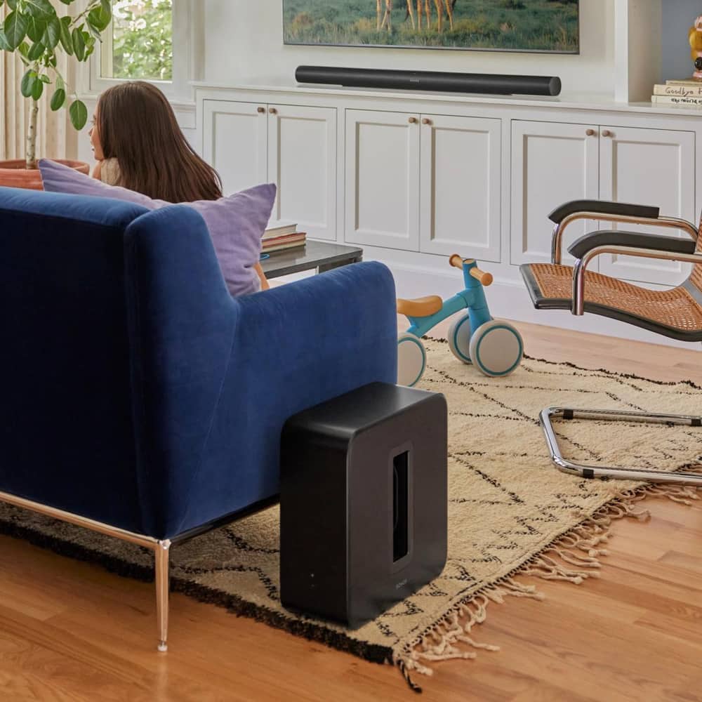 A Sub 4 next to a couch in a living room, being used with an Arc Ultra